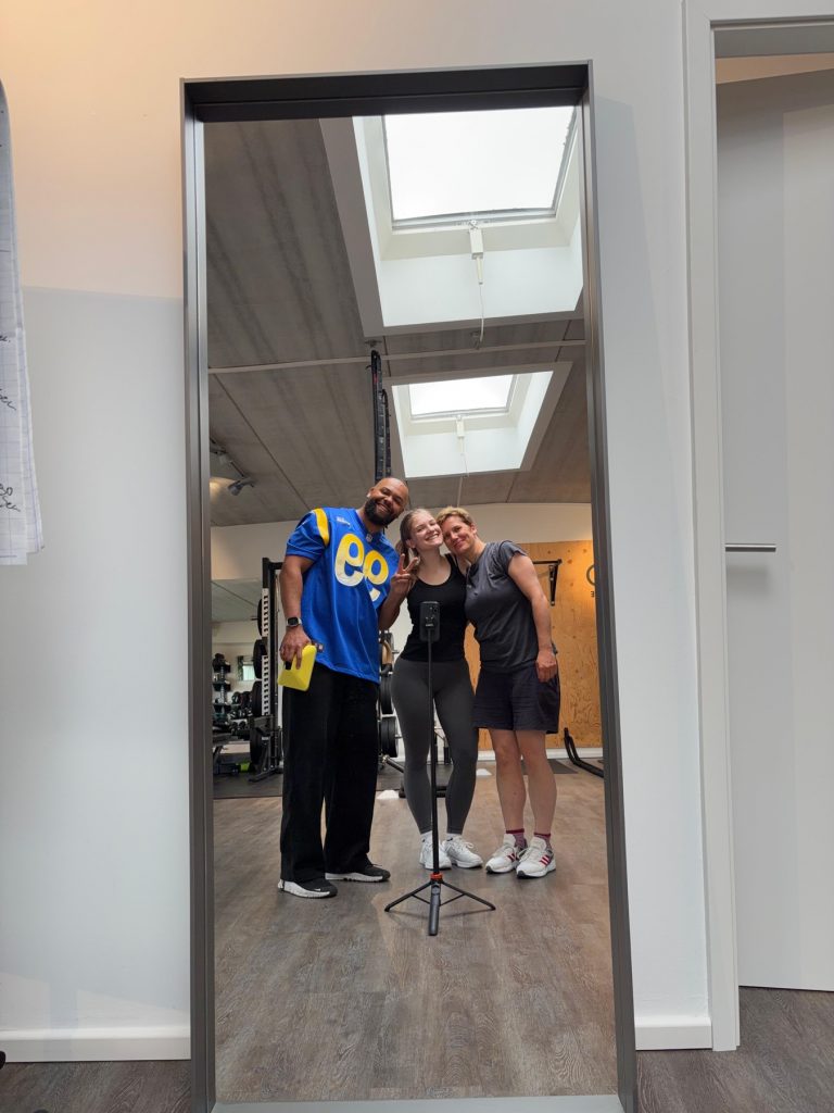 Jay Obasi mit Kundinnen, Gruppenfoto im Spiegel