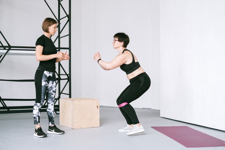 Zwei Frauen trainieren gemeinsam mit Widerstandsbaendern im Studio